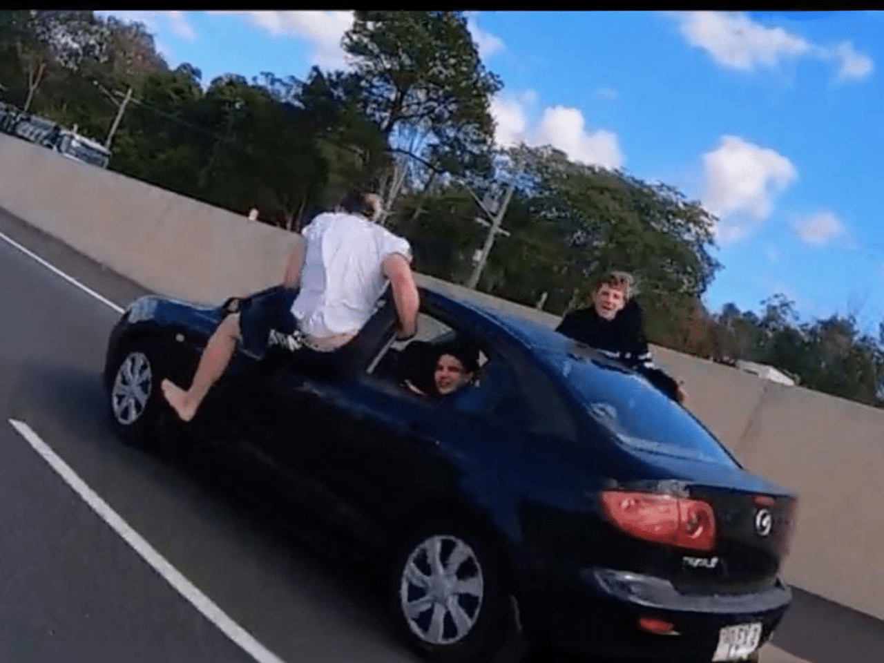 Daredevil Teens Hang Out of Moving Car, High-Fiving Motorists on Aussie Highway